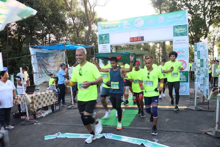 Runners bursting through the start ribbon