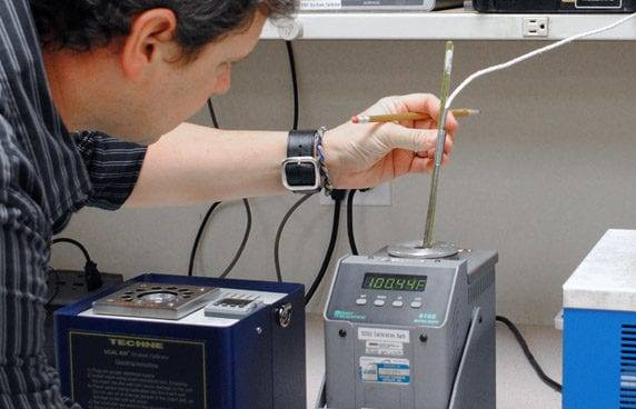 Technician calibrating a temperature probe in a dry-block calibrator